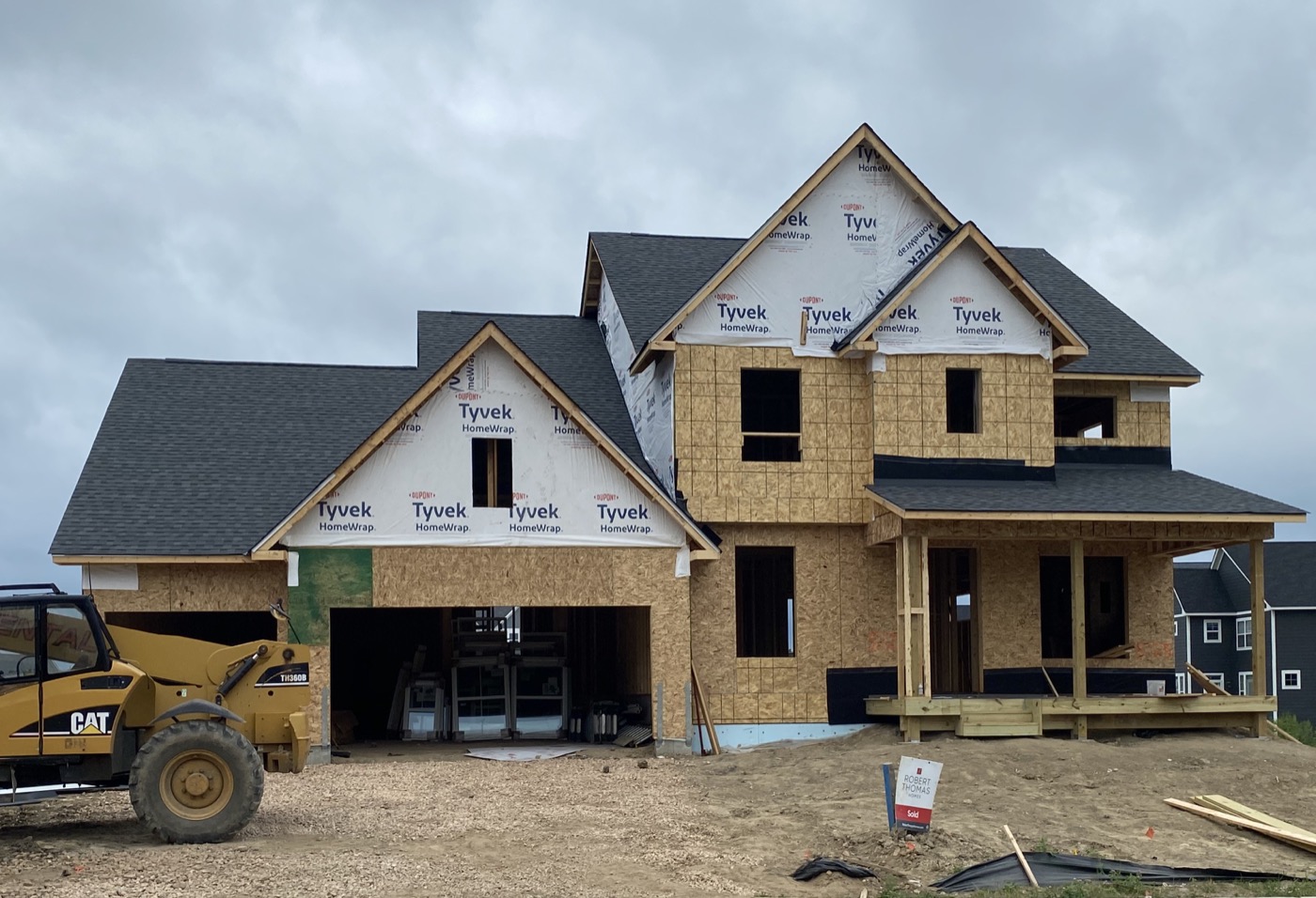 House under construction with OSB wall sheathing and wrapped gables.