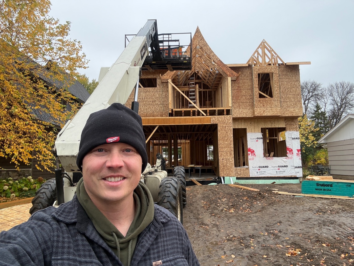 David Olson in front of a wood-framed home under construction.