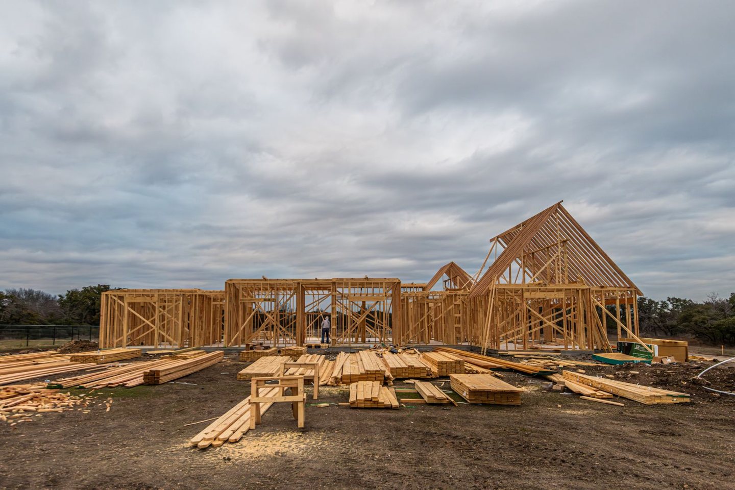 Wood-framed house under construction beneath an overcast sky.
