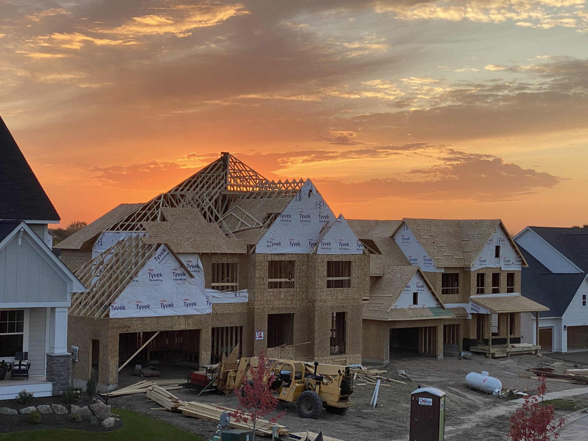 Homes with exposed roof framing at sunset.